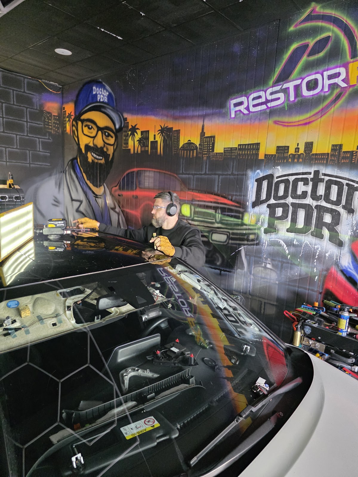 ציור קיר עם דמות "Doctor PDR" בסטודיו הדיטיילינג של RestorFX נוף הגליל