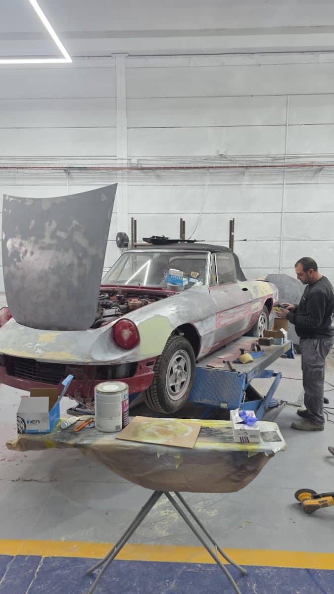 טכנאי RestorFX עובד על שיקום רכב קלאסי בגוון קרם במוסך נוף הגליל
