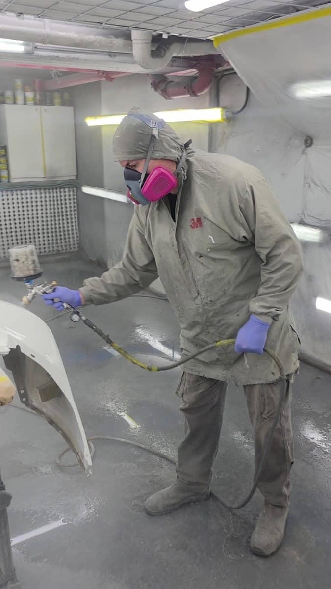 טכנאי RestorFX בציוד מיגון מלא במהלך עבודת צביעה במוסך נוף הגליל